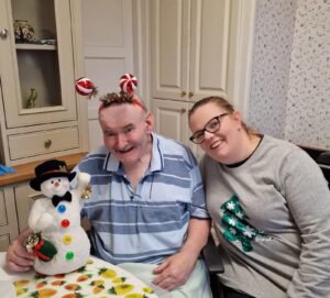A Blossom Homecare resident and a carer enjoying the christmas festivities.