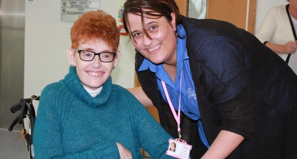 Carer and caree smiling to celebrate Blossom's record-breaking December.