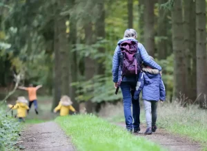 Woman and child walking through a forest to show the benefits of walking.