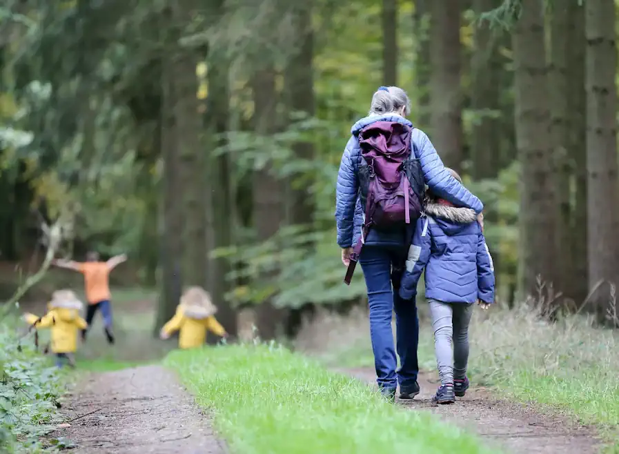 Woman and child walking through a forest to show the benefits of walking.