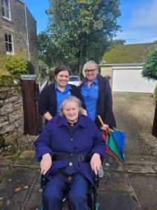 Blossom Healthcare staff taking a resident for a walk to promote wellbeing.