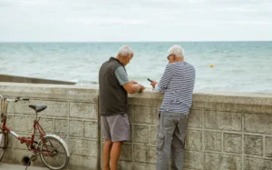 Two men looking out to sea to show them making the most of summer.