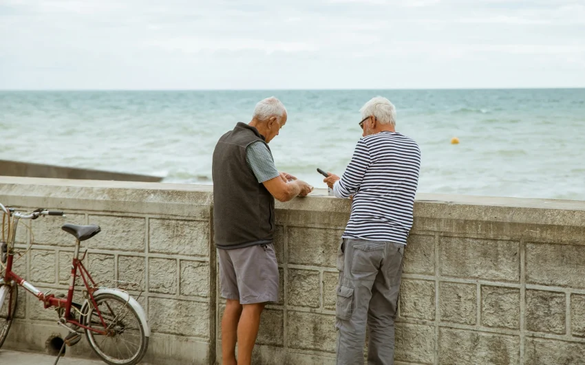 Two men looking out to sea to show them making the most of summer.