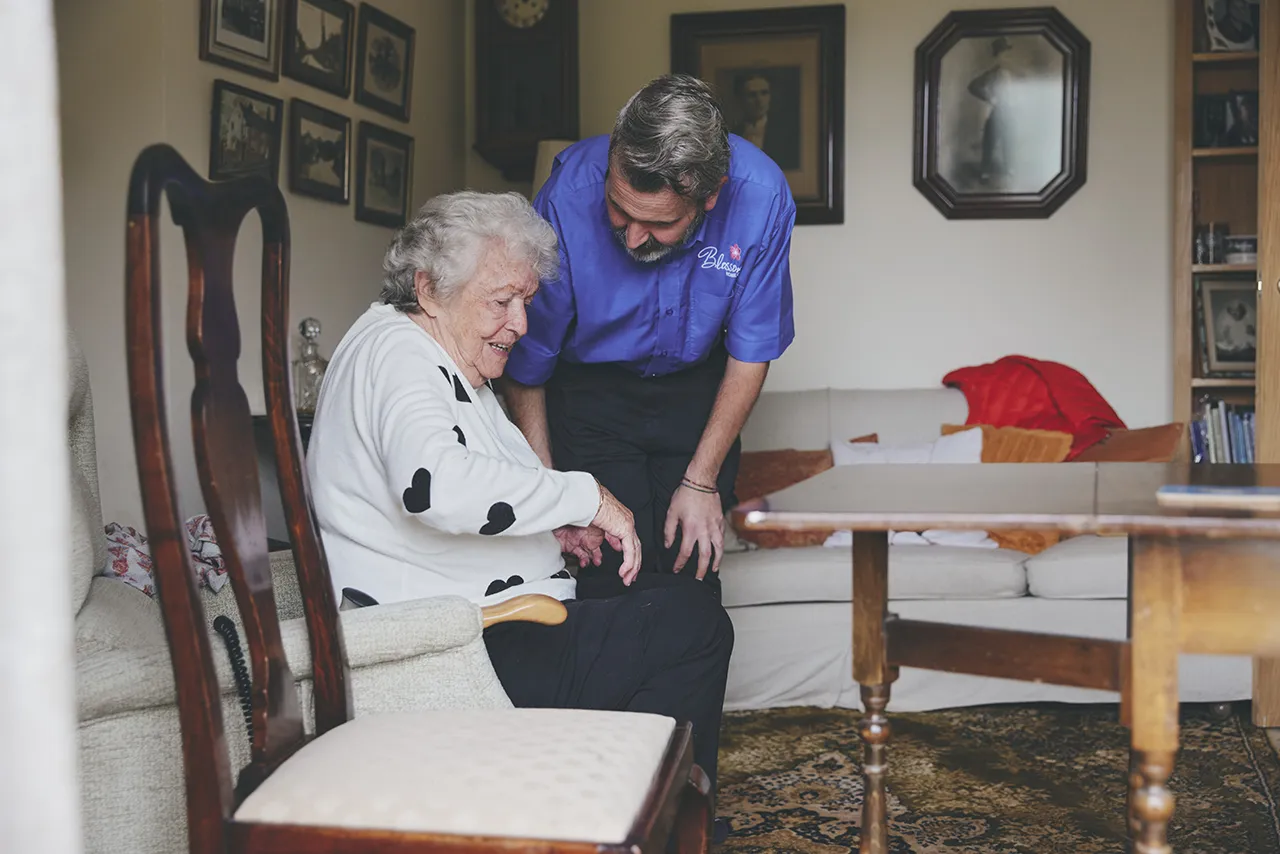 blossom home care carer helping client get up