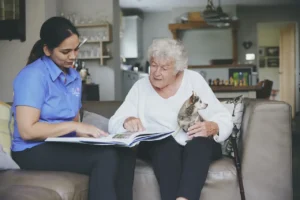 Blossom Home Care client reading book with their carer