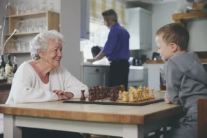 blossom home care client playing chess with grandson