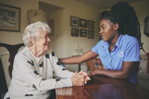 An elderly woman being comforted by her Blossom Home Care assistant.