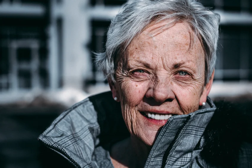 An older woman wearing a grey coat to show Blossom's dementia support.