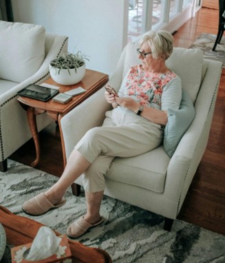 An elderly woman checking text messages on her phone.