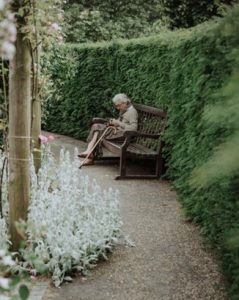 Senior woman sitting alone using a mobile phone.