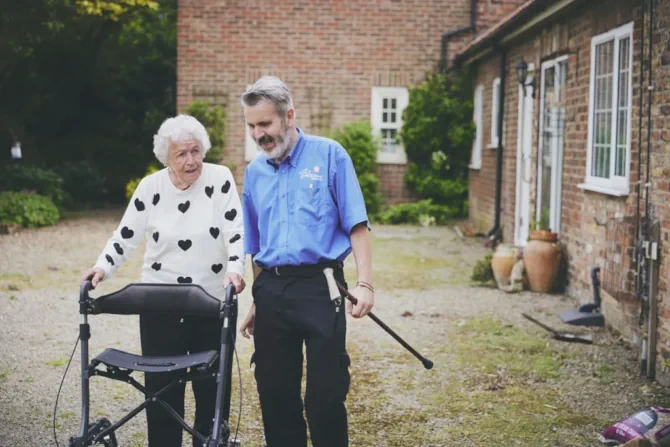 blossom home care client walking outside with a carer