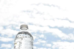 A water bottle standing up against the sky.
