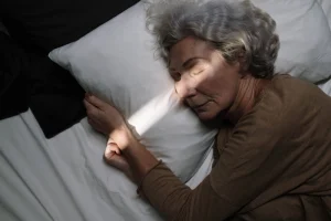 An elderly woman sleeping in bed.