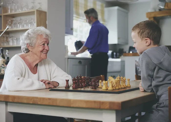 blossom home care client playing chess with grandson